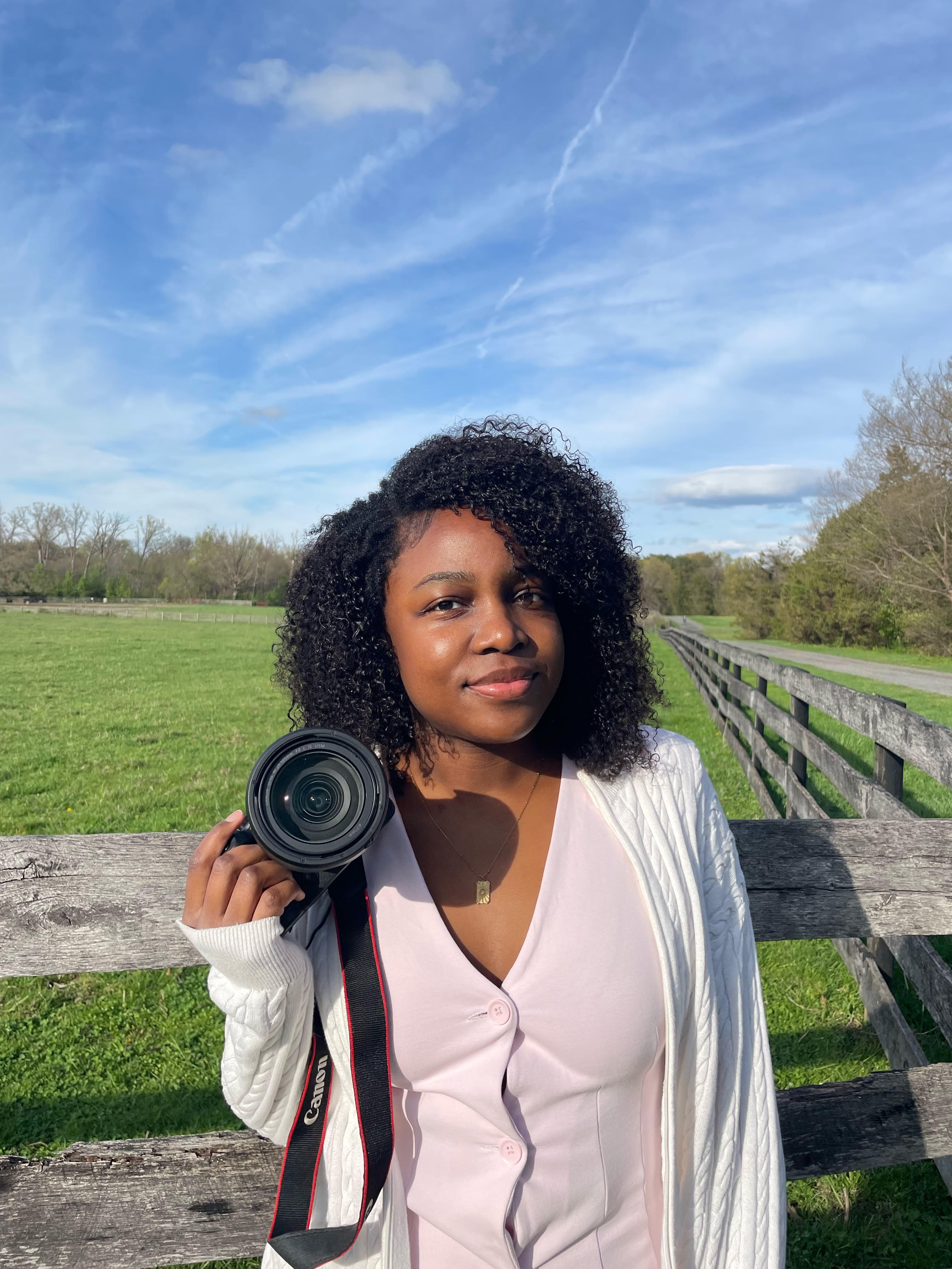 Tosiana holding her camera outdoors